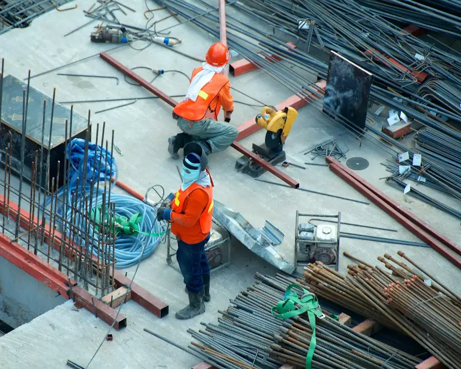Workers on a construction site among rebar and building materials