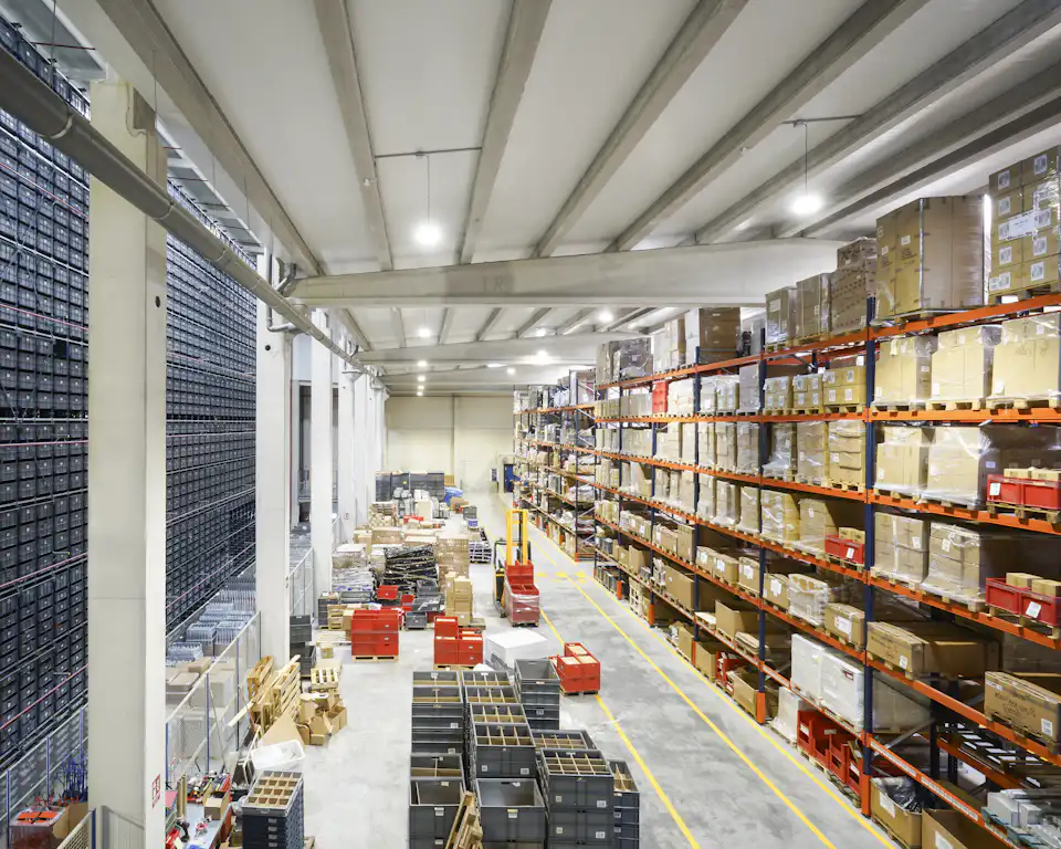 Warehouse racks stacked with cartons, where Odoo tracks lots, expiry dates and FEFO picking