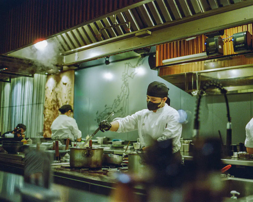 Chefs working in a commercial kitchen, where orders arrive from the Odoo point of sale