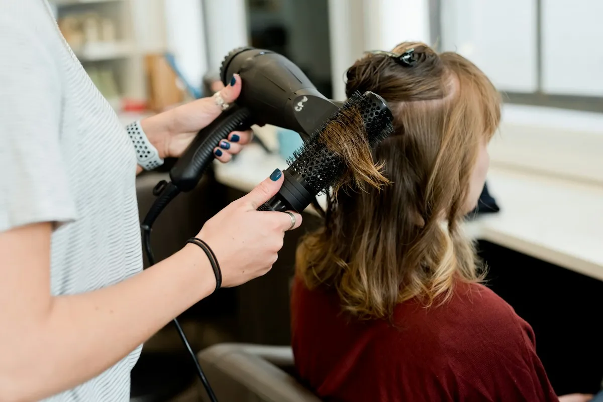 Hairstylist blow-drying a client's hair