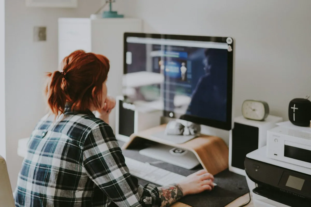 Designer working at a desktop computer in a studio