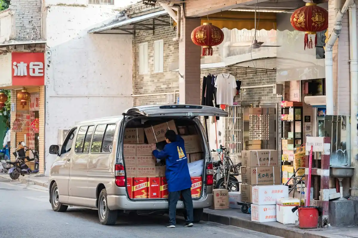 Delivery worker loading boxes into a van