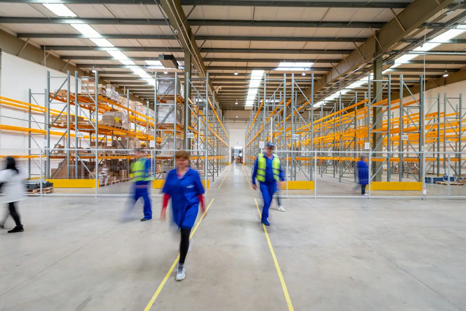 Warehouse staff walking down an aisle in a distribution warehouse