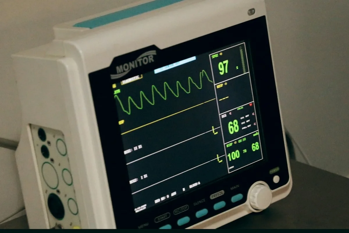 Patient monitor showing vital signs in a hospital room