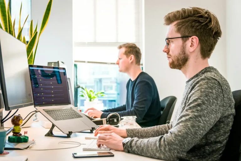 Two IT engineers working at their computers in an office