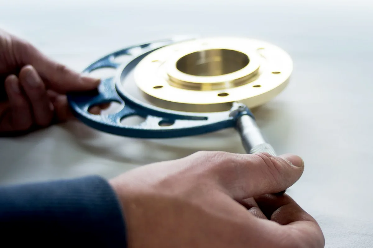 Hand checking a machined metal part during a quality inspection