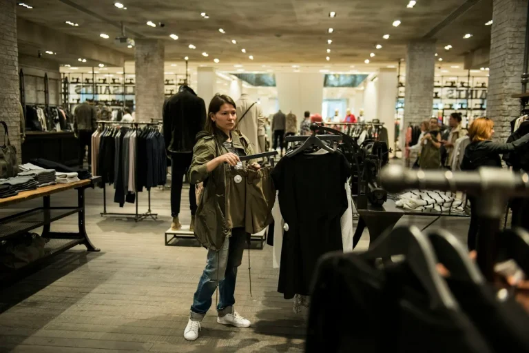 Shopper looking at clothes on a rail inside a retail store